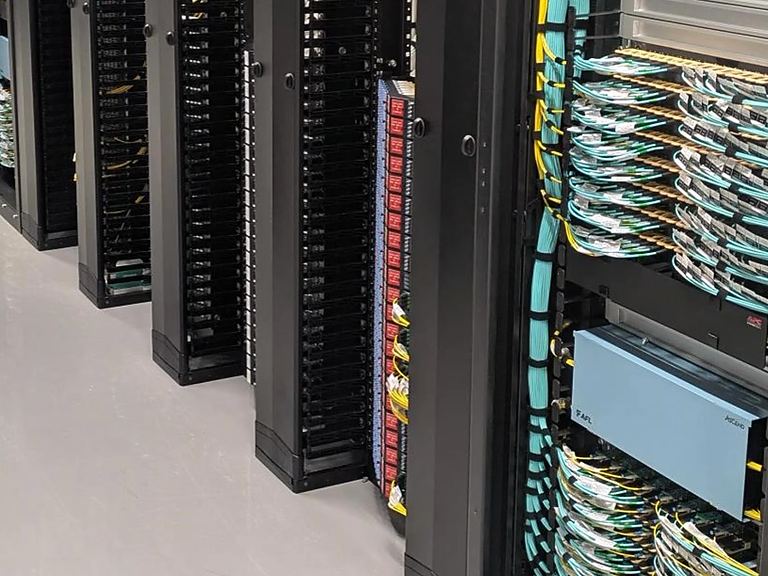 Equipment cabinet with fibre patch panels and neatly dressed aqua fibre