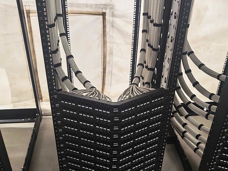Cable bundles entering a cabinet inside a hoarded fit-out area