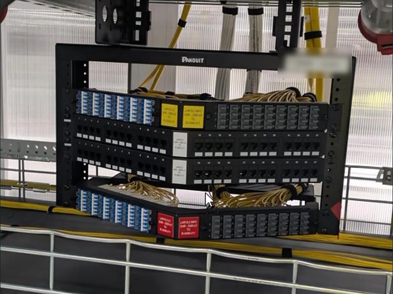 Overhead fibre distribution rack above a cable tray