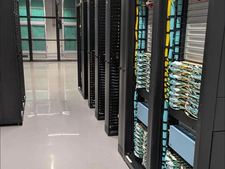 Data-centre aisle with cabinets and overhead cable trays