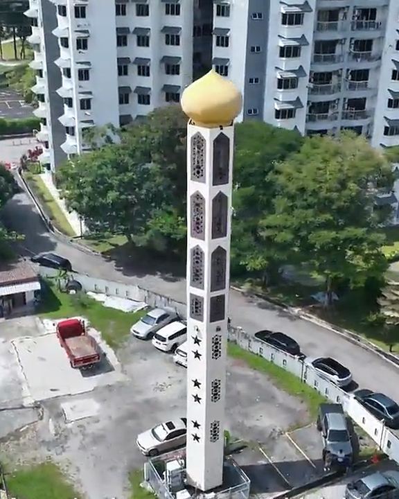 Aerial view of a minaret-style structure among houses and apartment blocks