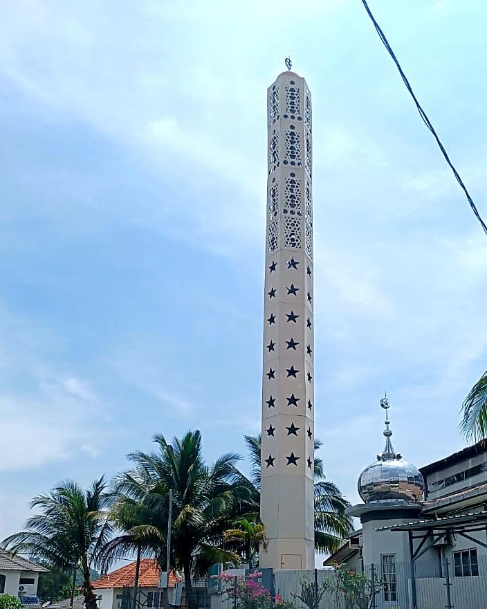 White minaret-style tower beside a mosque